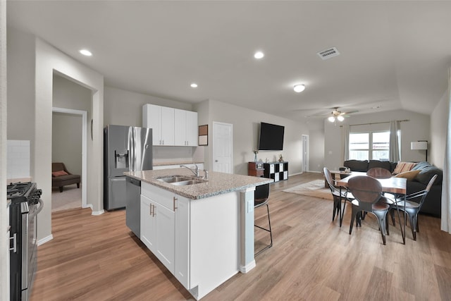 kitchen with stainless steel appliances, visible vents, open floor plan, white cabinetry, and a sink