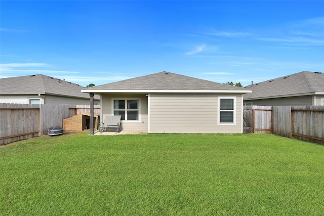 back of property with a fenced backyard, a lawn, and a patio