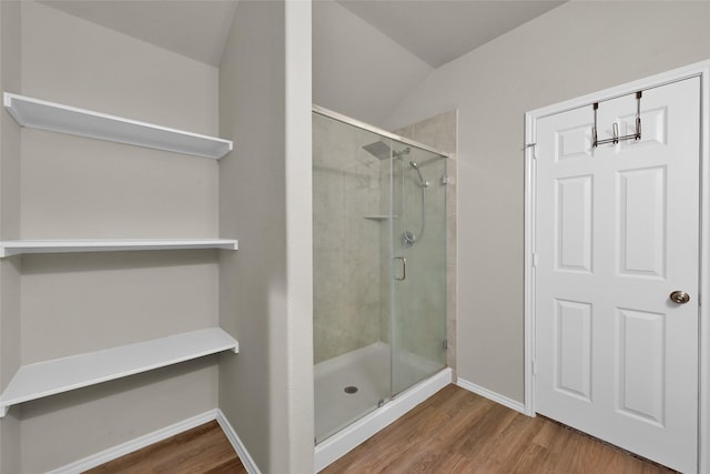 full bathroom featuring baseboards, wood finished floors, and a shower stall