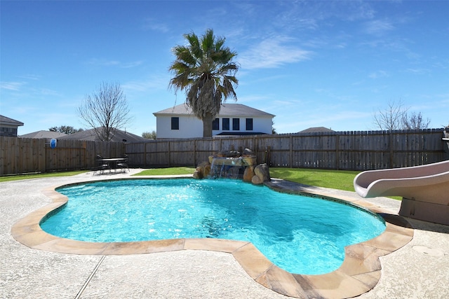 view of swimming pool with a patio, a fenced backyard, a fenced in pool, and a water slide