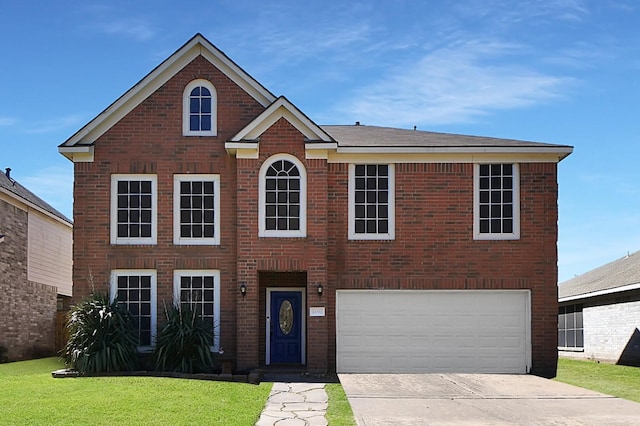 colonial home with brick siding, driveway, an attached garage, and a front lawn