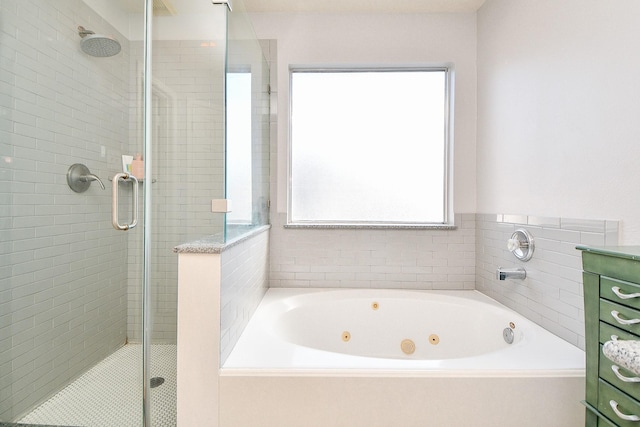 full bathroom featuring a shower stall and a jetted tub