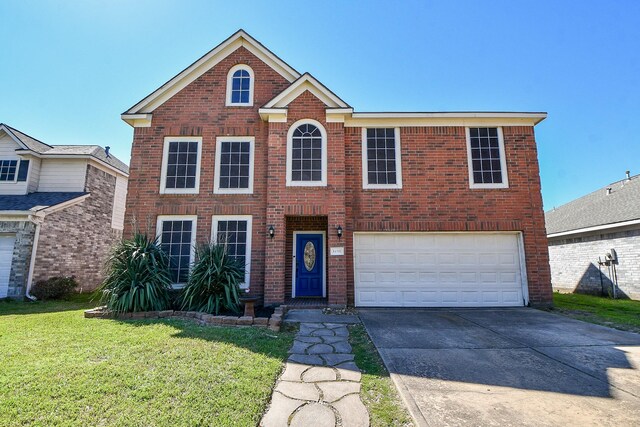 view of front of house featuring brick siding, a front yard, an attached garage, and driveway