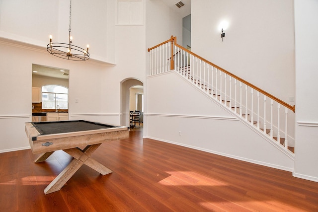 recreation room with billiards, wood finished floors, visible vents, a high ceiling, and a chandelier