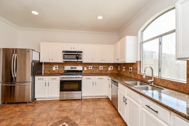 kitchen with a wealth of natural light, ornamental molding, a sink, backsplash, and appliances with stainless steel finishes