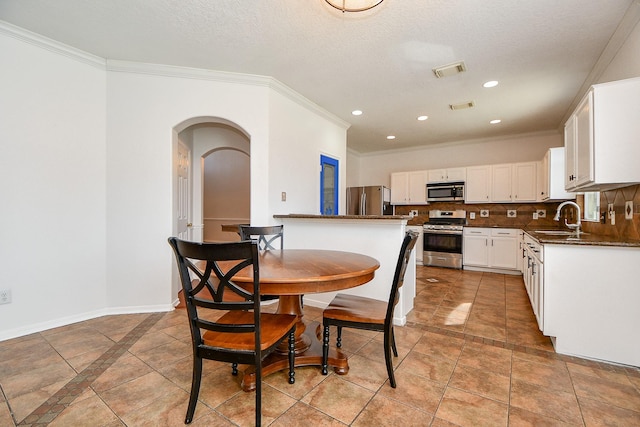 dining area with arched walkways, visible vents, recessed lighting, and baseboards