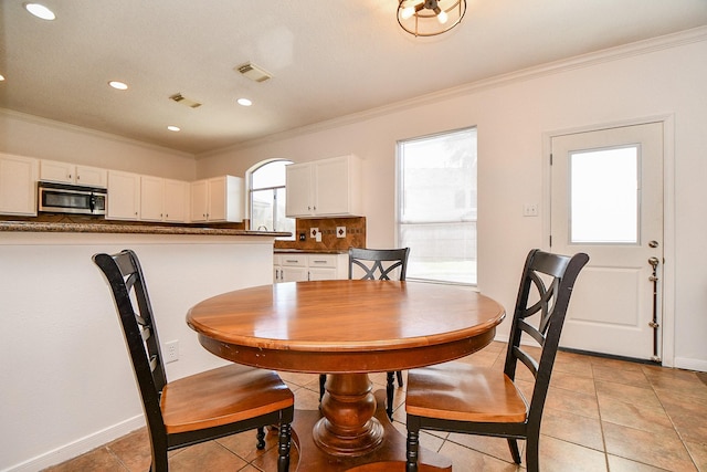 dining area featuring visible vents and crown molding