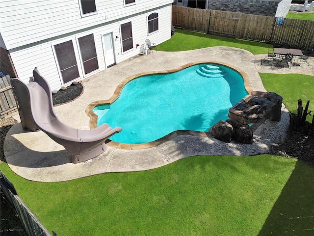 view of pool with a fenced backyard, a yard, and a patio