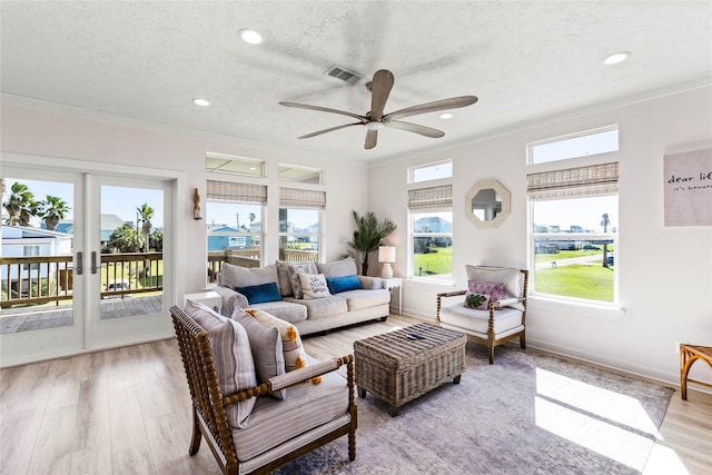 interior space with a textured ceiling, visible vents, crown molding, and wood finished floors