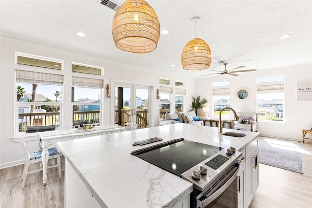 kitchen with a sink, light wood-style flooring, open floor plan, and electric range oven