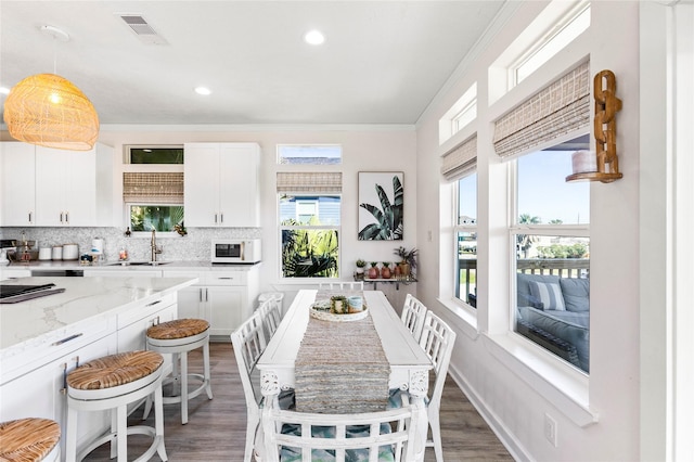 kitchen featuring visible vents, dark wood finished floors, backsplash, white cabinetry, and a sink