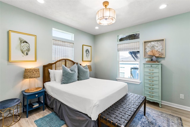 bedroom with multiple windows, recessed lighting, wood finished floors, and baseboards