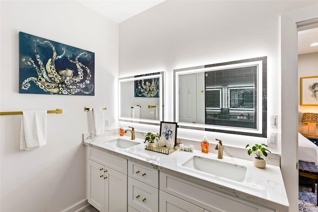 bathroom with double vanity, a sink, and ensuite bathroom