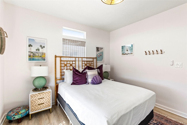 bedroom with baseboards and wood finished floors