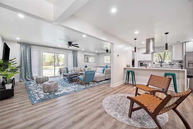 living room featuring light wood-style floors, baseboards, and recessed lighting