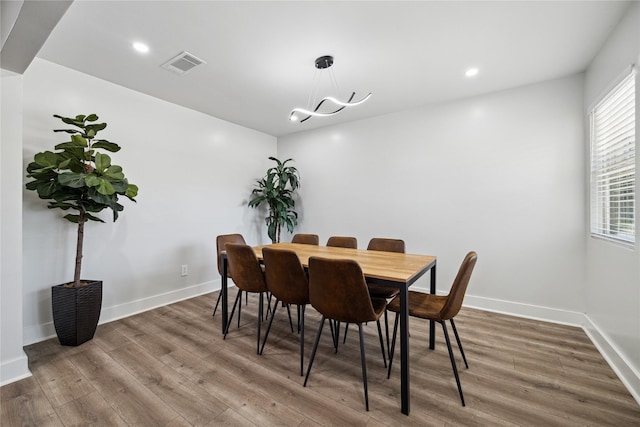 dining space featuring baseboards, visible vents, wood finished floors, and recessed lighting