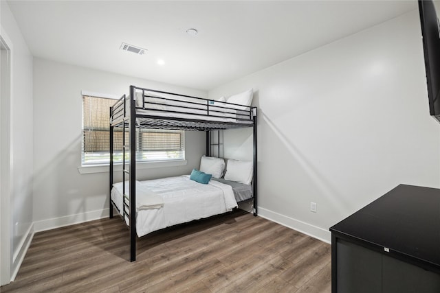 unfurnished bedroom featuring baseboards, visible vents, and wood finished floors