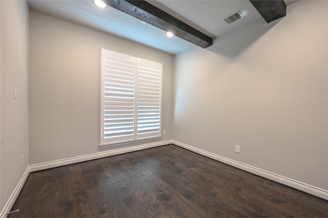 spare room with dark wood-style flooring, visible vents, beamed ceiling, and baseboards