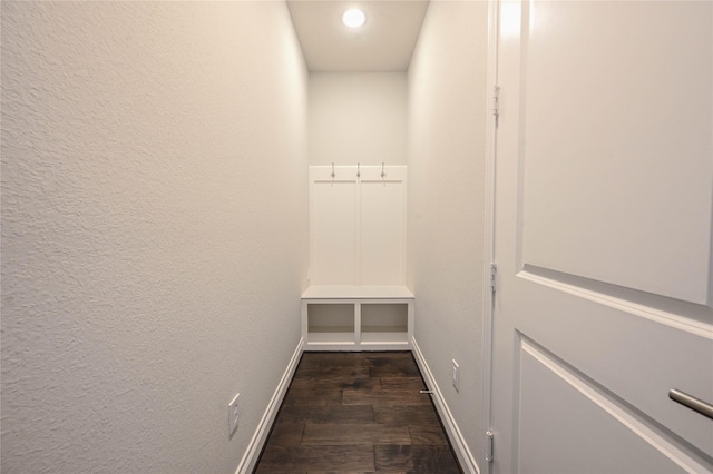 mudroom with baseboards, dark wood-style flooring, and a textured wall