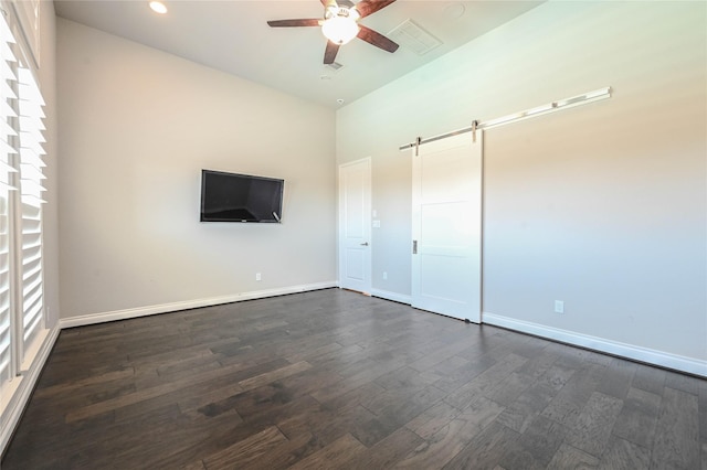 unfurnished bedroom featuring a barn door, recessed lighting, dark wood-style flooring, visible vents, and baseboards