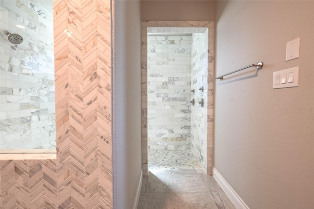 full bathroom featuring baseboards and a tile shower