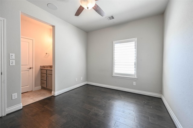 unfurnished bedroom featuring dark wood-style flooring, visible vents, and baseboards