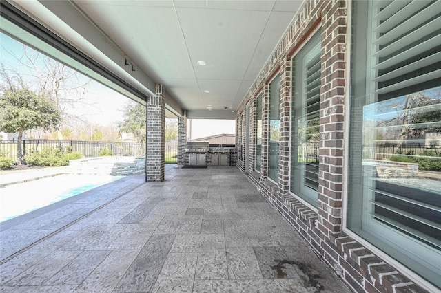 view of patio with a fenced in pool, fence, and exterior kitchen