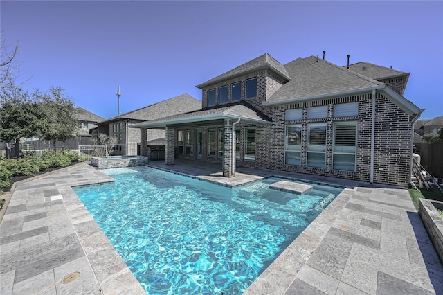 view of swimming pool featuring a pool with connected hot tub, a fenced backyard, and a patio