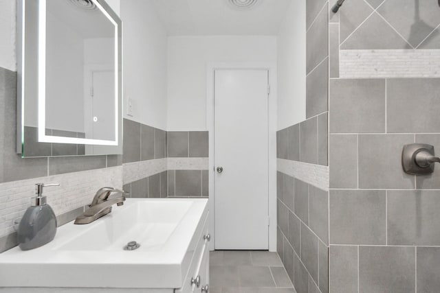 bathroom with tile walls, vanity, and tile patterned floors