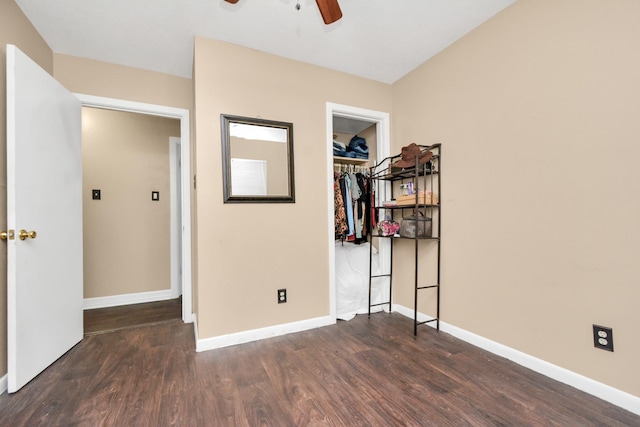 bedroom featuring wood finished floors, a ceiling fan, baseboards, a closet, and a walk in closet