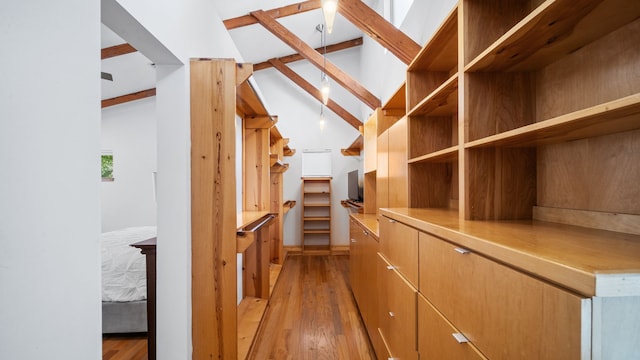 spacious closet featuring lofted ceiling with beams and light wood-style flooring