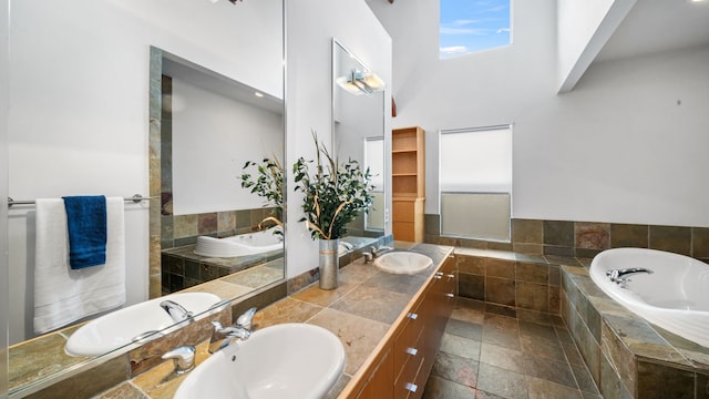 bathroom featuring stone tile floors, a bath, and a sink