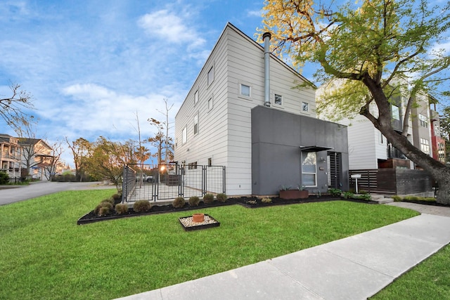 view of side of home with a lawn and fence