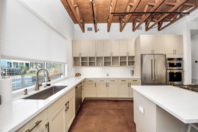 kitchen with a sink, concrete floors, light countertops, stainless steel appliances, and open shelves