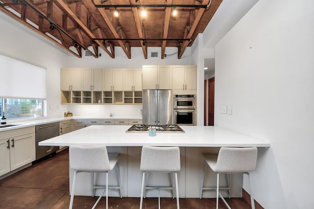 kitchen with visible vents, appliances with stainless steel finishes, light countertops, and a kitchen bar