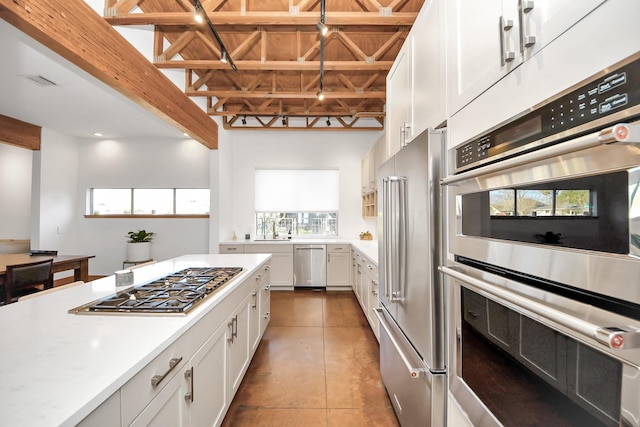 kitchen featuring tile patterned flooring, appliances with stainless steel finishes, white cabinetry, and light countertops