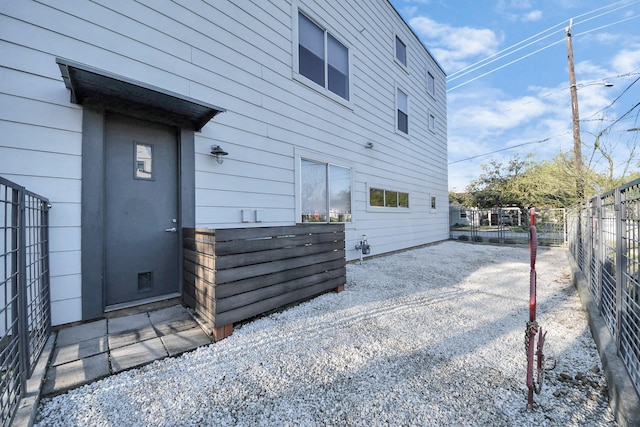 back of property featuring gravel driveway and fence