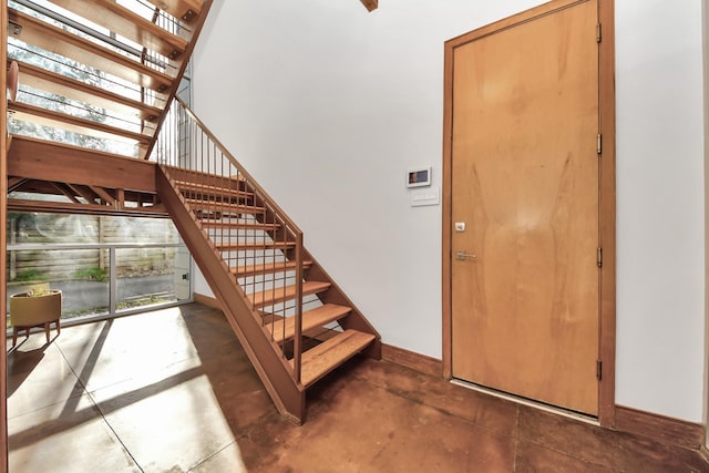 stairs with baseboards and concrete floors