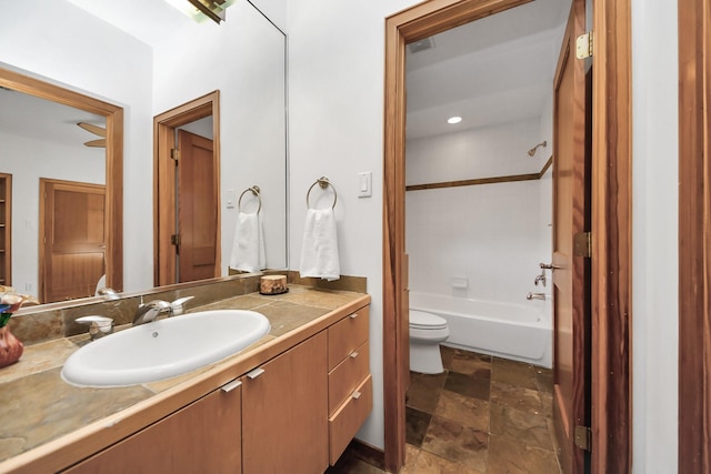 full bath with visible vents, toilet, stone finish floor, washtub / shower combination, and vanity