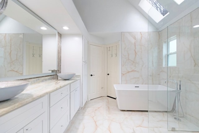 full bath featuring marble finish floor, a marble finish shower, vaulted ceiling with skylight, double vanity, and a freestanding bath