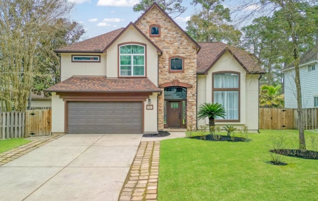 view of front of house featuring stucco siding, a front lawn, driveway, and fence