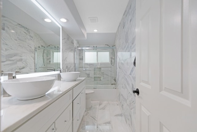 full bath with double vanity, enclosed tub / shower combo, marble finish floor, and a sink