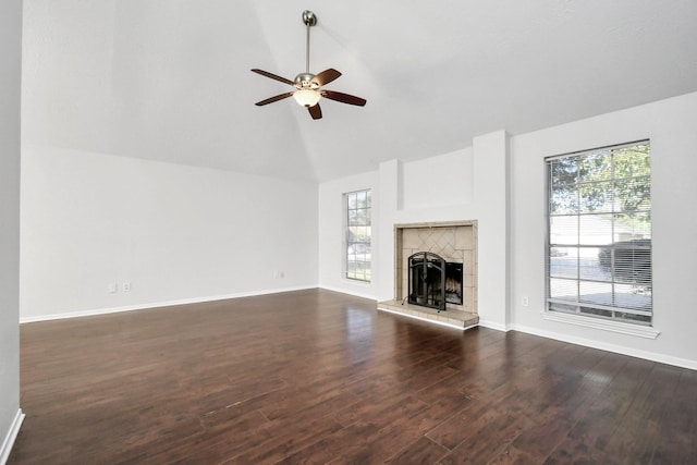 unfurnished living room featuring a wealth of natural light, dark wood-style flooring, and a tile fireplace