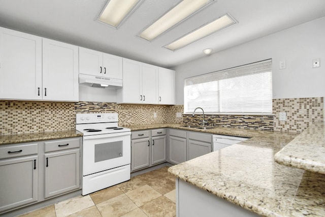 kitchen with light stone counters, backsplash, a sink, white appliances, and under cabinet range hood