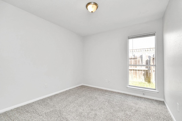 spare room with baseboards and carpet flooring