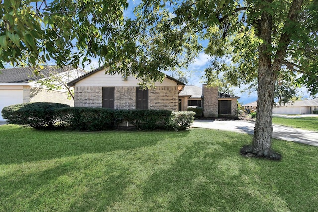 ranch-style home featuring a garage, brick siding, and a front yard