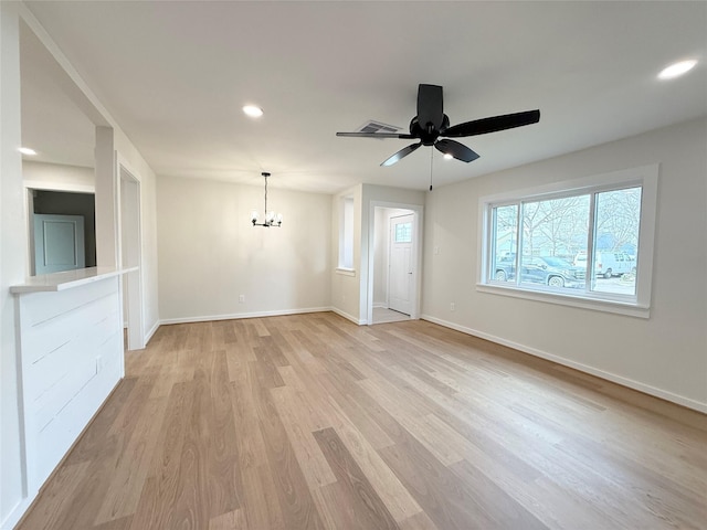 unfurnished living room with light wood-style floors, recessed lighting, baseboards, and ceiling fan with notable chandelier