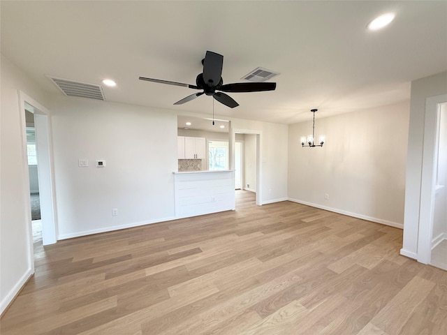 unfurnished living room with ceiling fan with notable chandelier, light wood-type flooring, visible vents, and recessed lighting