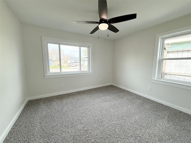 unfurnished room with carpet floors, baseboards, and a ceiling fan