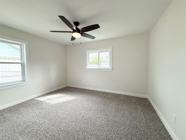 carpeted empty room featuring a ceiling fan and baseboards